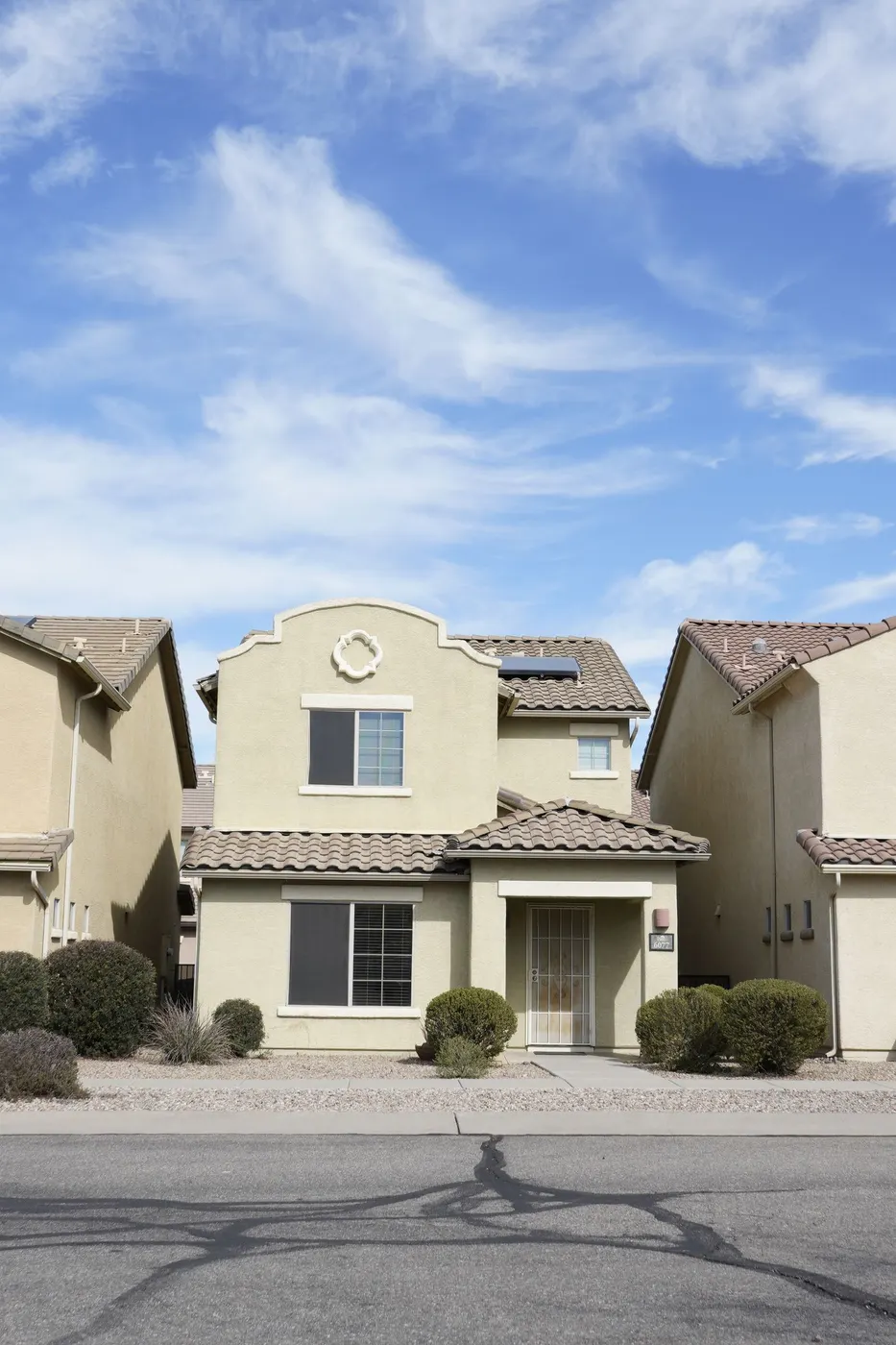 Two-story stucco homes under a blue sky